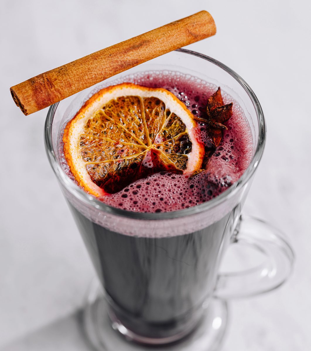 Glass of mulled wine garnished with an orange slice and a cinnamon stick