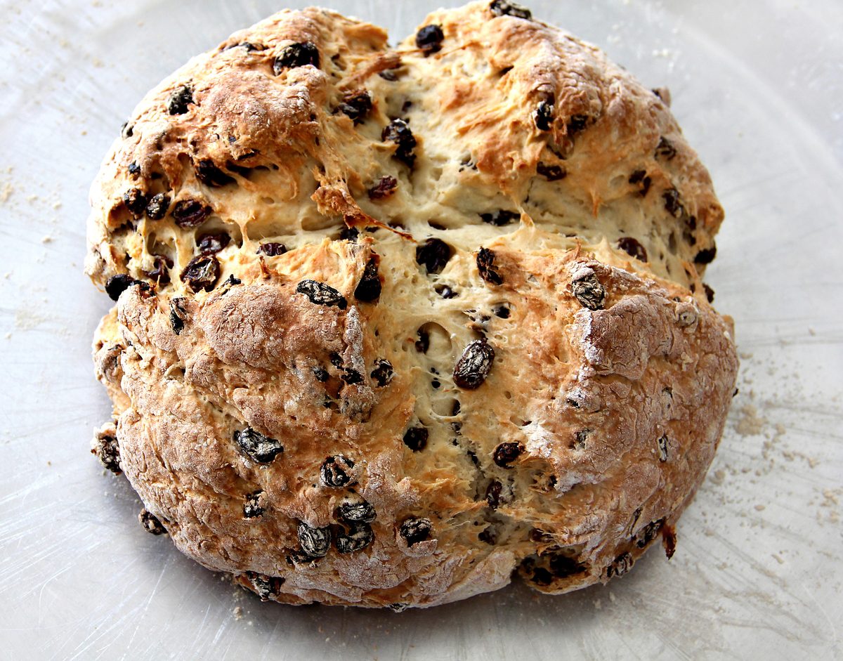 Round loaf of Irish soda bread with raisins and a cross scored on top