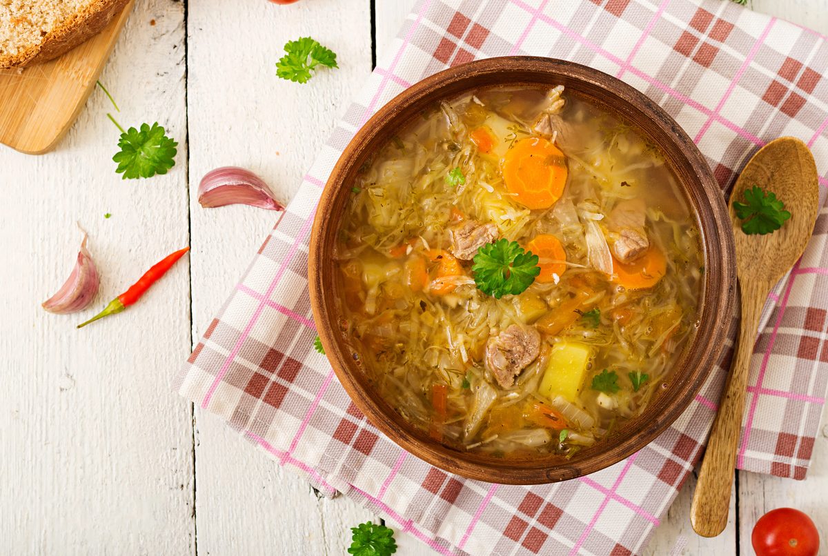 Kapustnica, sauerkraut soup with sausage and mushrooms, in a bowl