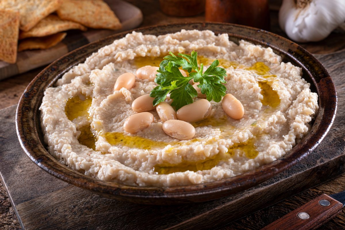 Bowl of mashed white beans with garlic and olive oil