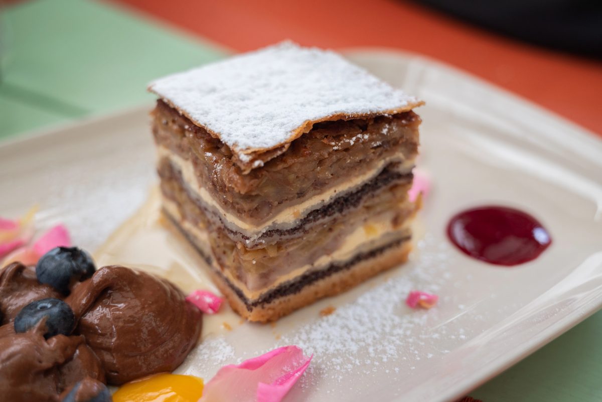 Slice of layered gibanica pastry with poppy seed, walnut, apple and cheese fillings