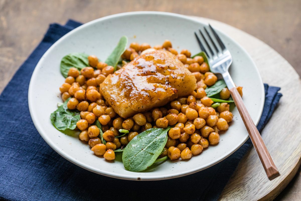 Salt cod with chickpeas and spinach on a plate
