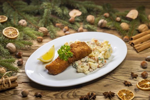 Breaded fried carp with Czech potato salad on a white plate