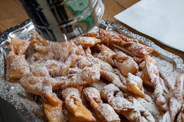Twisted fried pastries dusted with powdered sugar, similar to Danish klejner