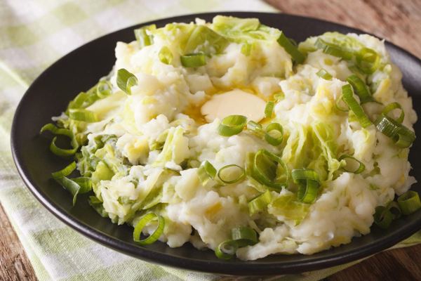 Colcannon, mashed potatoes with savoy cabbage and butter, in a dark bowl