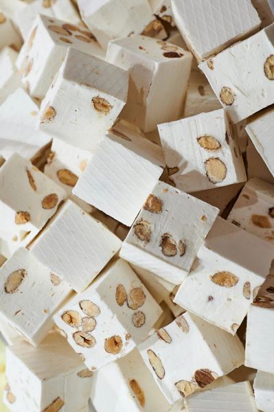 Pieces of white Italian torrone nougat studded with almonds