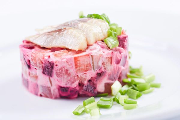 Swedish herring salad with beetroot, topped with herring and green onion