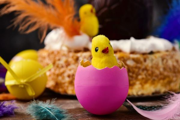 Mona de Pascua Easter cake decorated with a toy chick, feathers and eggs