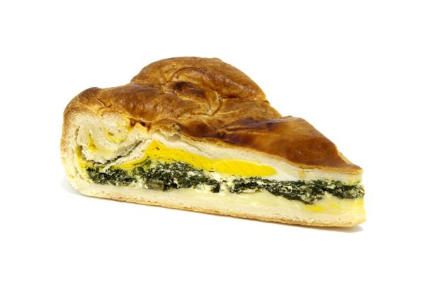 Slice of torta pasqualina, an Easter greens pie with a whole egg yolk inside