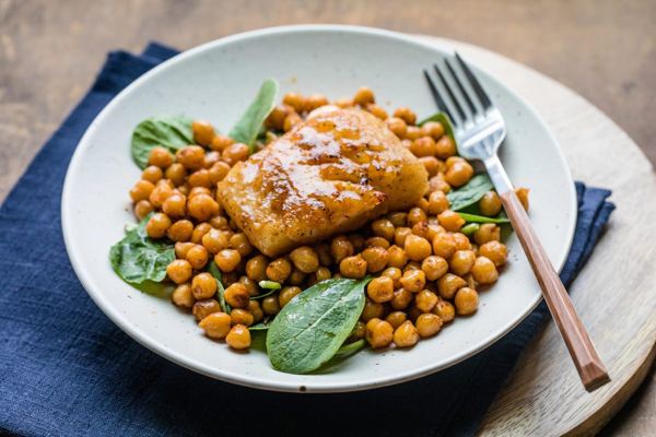 Salt cod with chickpeas and spinach on a plate