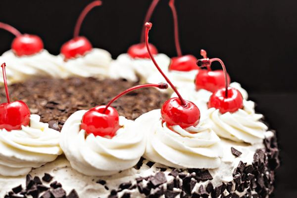 Black Forest cherry cake with whipped cream, chocolate shavings and cherries