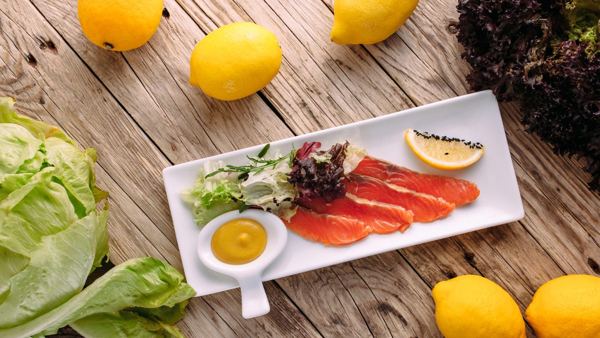 Gravlaks slices with mustard sauce and lemon