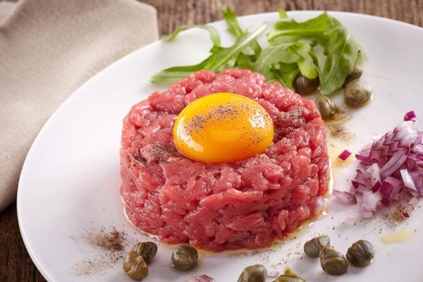 Beef tartare with a raw egg yolk, capers and red onion