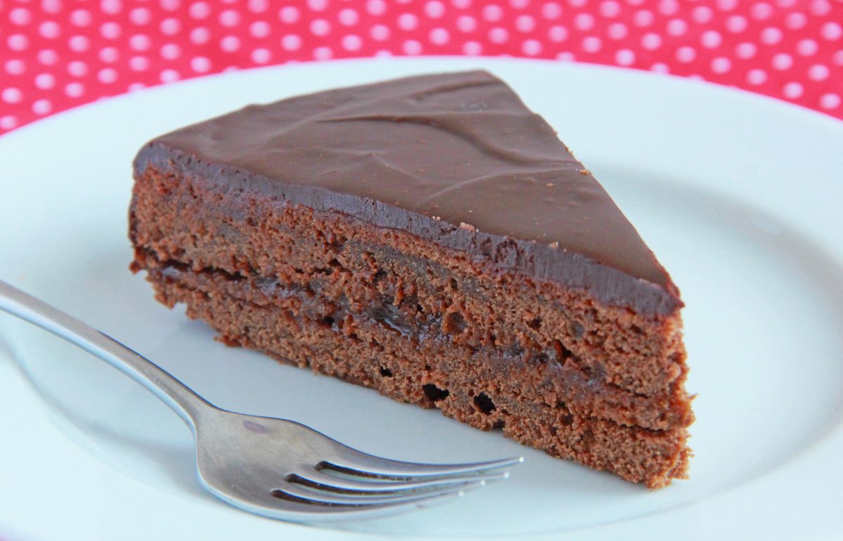 Slice of glazed chocolate torte on a plate